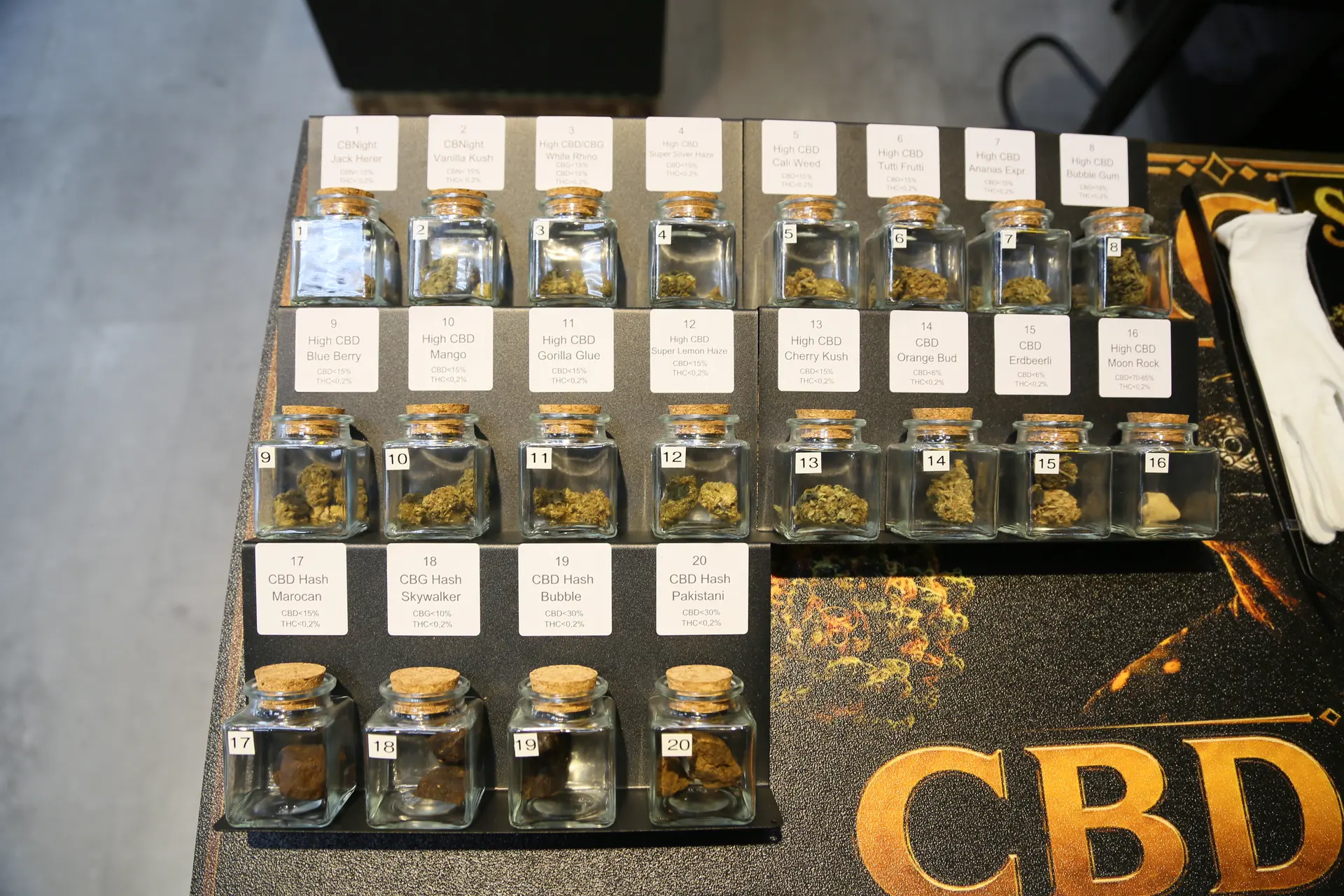 Draufsicht auf die CBD-Bar mit vielen beschrifteten Gläsern voller Blüten