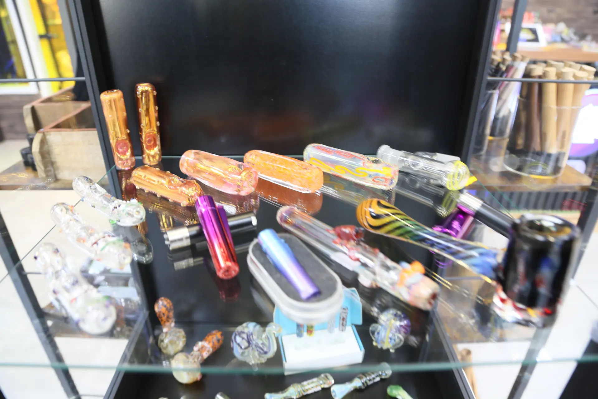 Nahaufnahme einer Vitrine mit bunten Glaspfeifen und Zubehör